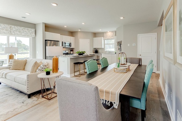 dining room featuring plenty of natural light, sink, and light wood-type flooring