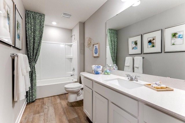 full bathroom with hardwood / wood-style flooring, vanity, toilet, and shower / bath combination