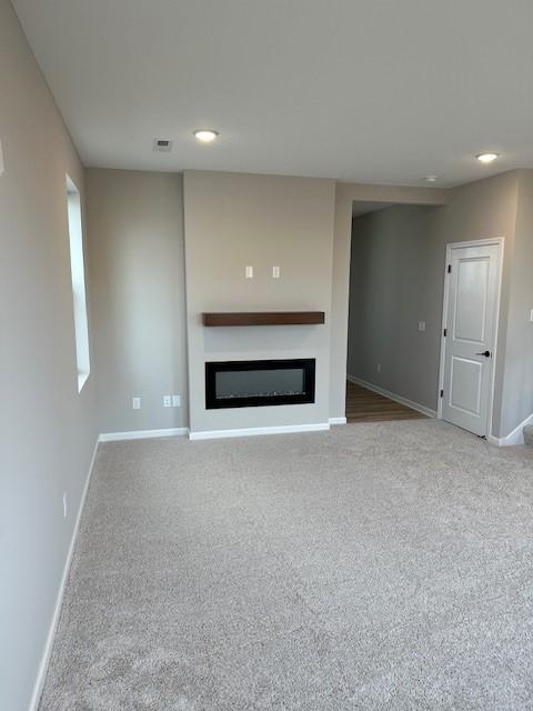 unfurnished living room featuring carpet