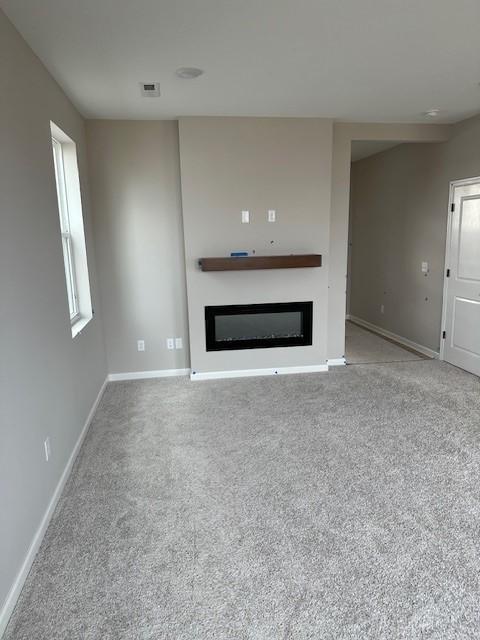 unfurnished living room featuring light colored carpet