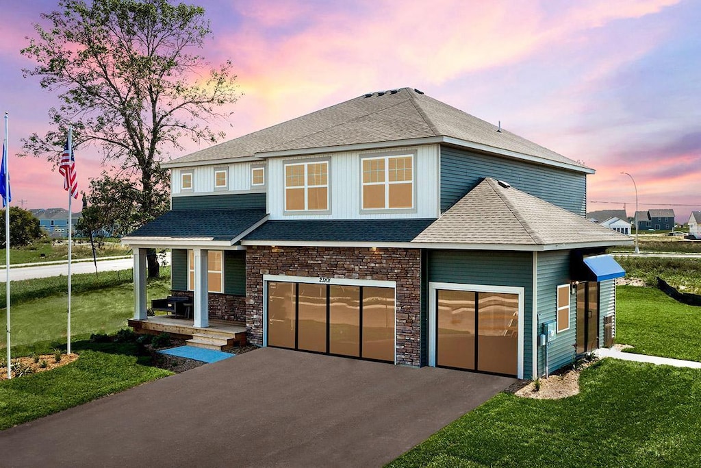 view of front of property with a garage and a yard