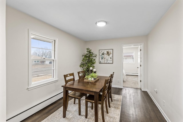 dining area featuring a baseboard heating unit and dark wood-type flooring