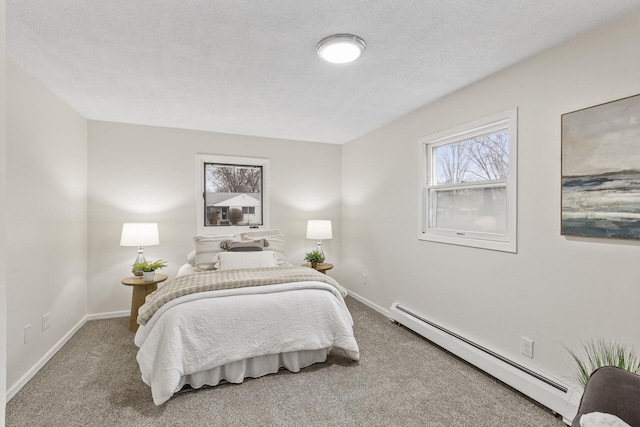 carpeted bedroom with a textured ceiling and a baseboard heating unit