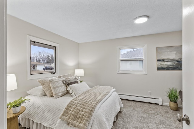 carpeted bedroom with a baseboard radiator and a textured ceiling