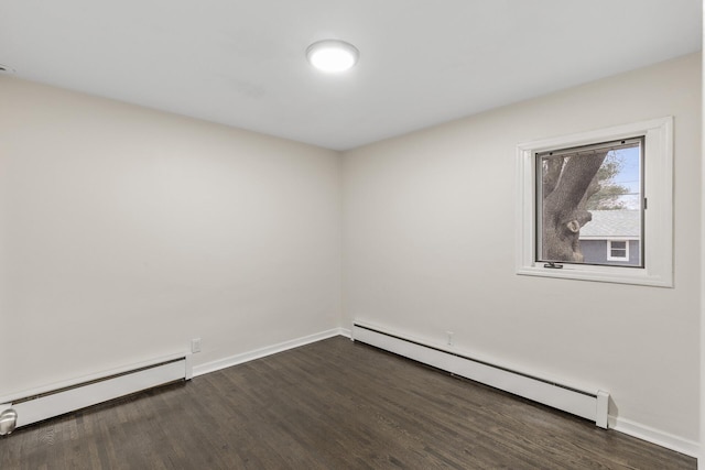 unfurnished room with dark wood-type flooring and baseboard heating