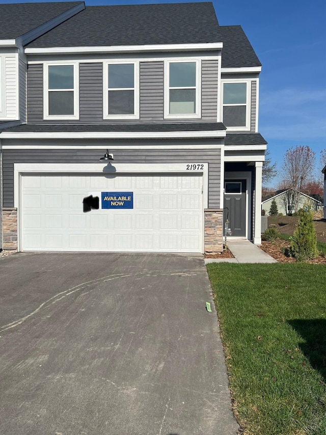 view of front of property featuring a garage and a front lawn