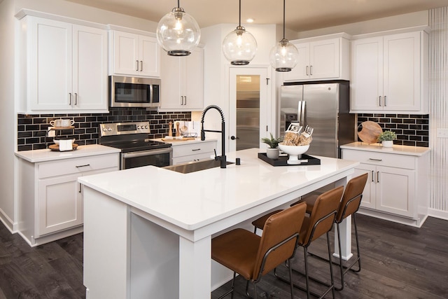 kitchen featuring hanging light fixtures, white cabinetry, and appliances with stainless steel finishes