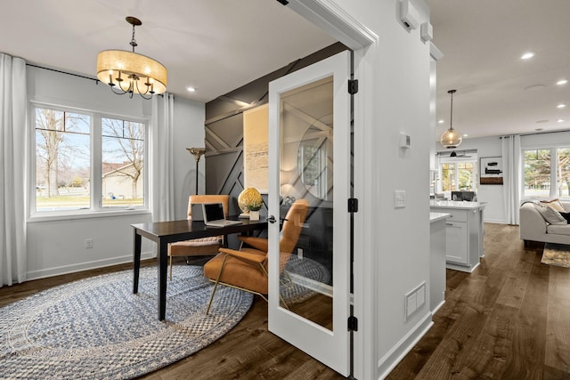 office with dark hardwood / wood-style floors and a notable chandelier