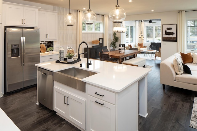 kitchen featuring white cabinetry, appliances with stainless steel finishes, sink, and an island with sink