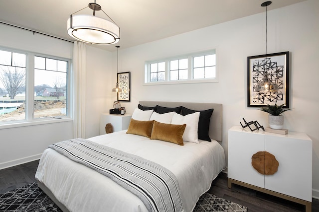 bedroom with dark hardwood / wood-style floors and multiple windows