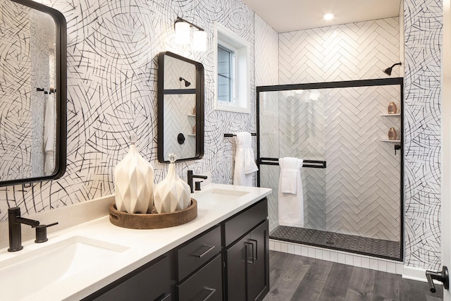 bathroom featuring hardwood / wood-style flooring, vanity, and tiled shower