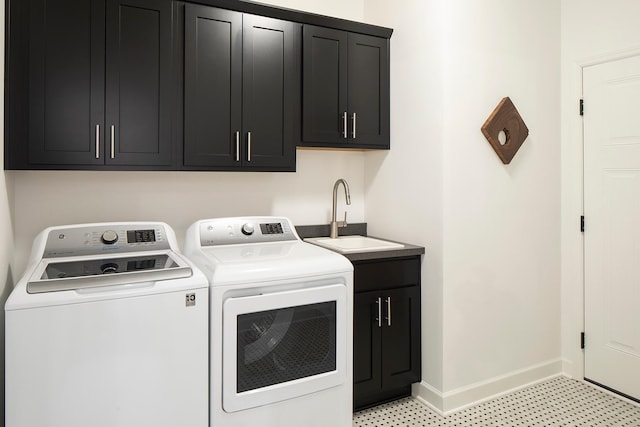 clothes washing area with cabinets, washing machine and clothes dryer, and sink