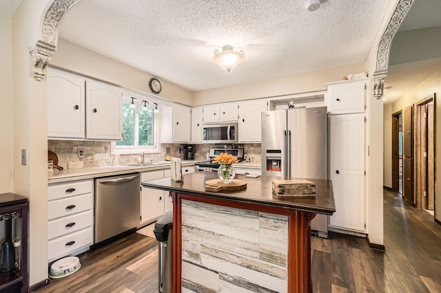 11132 100th Pl N, Maple Grove, MN 55369 - kitchen with dark wood-style flooring, white cabinets, stainless steel appliances, backsplash, and a textured ceiling