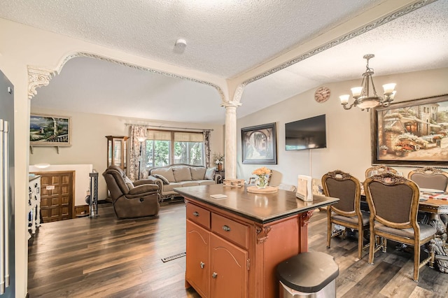 11132 100th Pl N, Maple Grove, MN 55369 - kitchen featuring dark wood-style flooring, a textured ceiling, dark countertops, lofted ceiling, and ornate columns