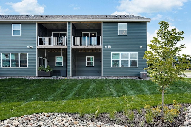 rear view of property featuring a yard and central AC unit