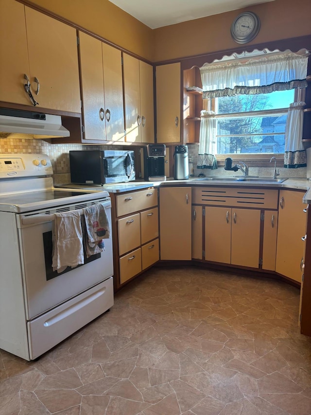 kitchen with electric stove, sink, and backsplash