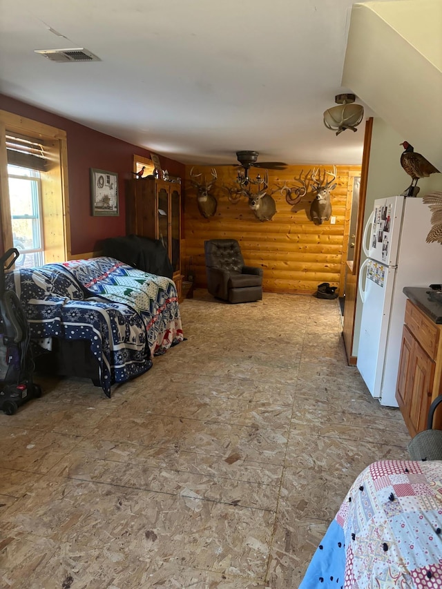 bedroom featuring white fridge and log walls