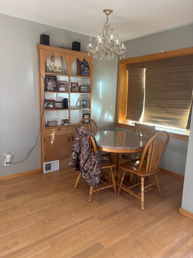 dining room with a notable chandelier and light wood-type flooring