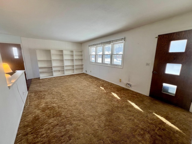 unfurnished living room featuring dark carpet