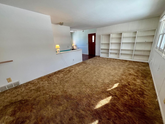 unfurnished living room with dark carpet