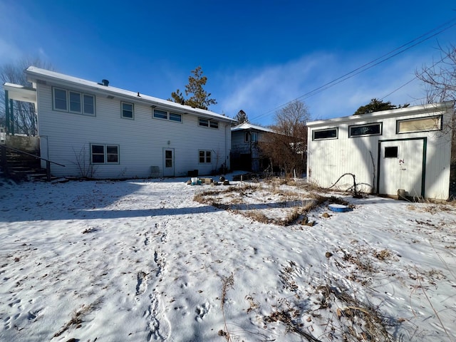 view of snow covered rear of property