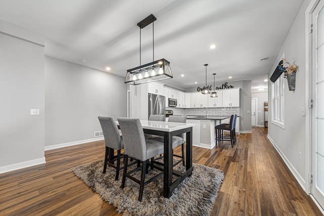 dining area featuring sink and dark hardwood / wood-style flooring