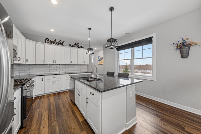 5051 216th St W, Farmington, MN 55024 - kitchen featuring a sink, appliances with stainless steel finishes, decorative backsplash, an island with sink, and dark wood-style flooring