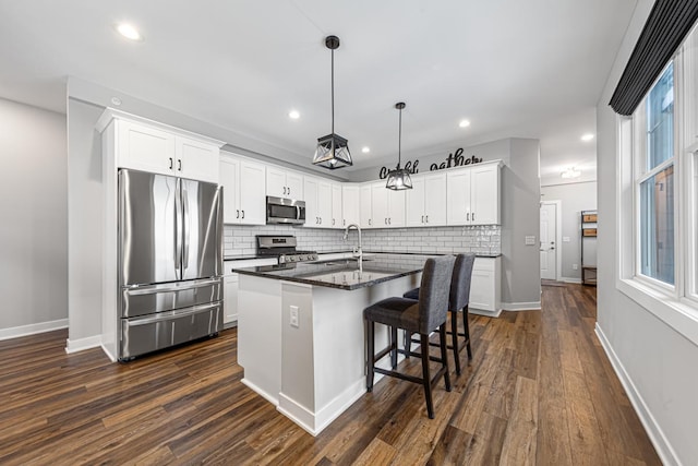 5051 216th St W, Farmington, MN 55024 - kitchen featuring stainless steel appliances, a center island with sink, decorative backsplash, white cabinets, and recessed lighting