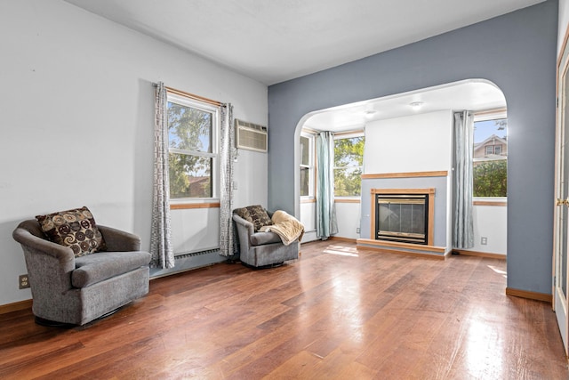 990 Virginia St, Saint Paul, MN 55117 - living area with arched walkways, a baseboard radiator, a wall unit AC, and wood finished floors