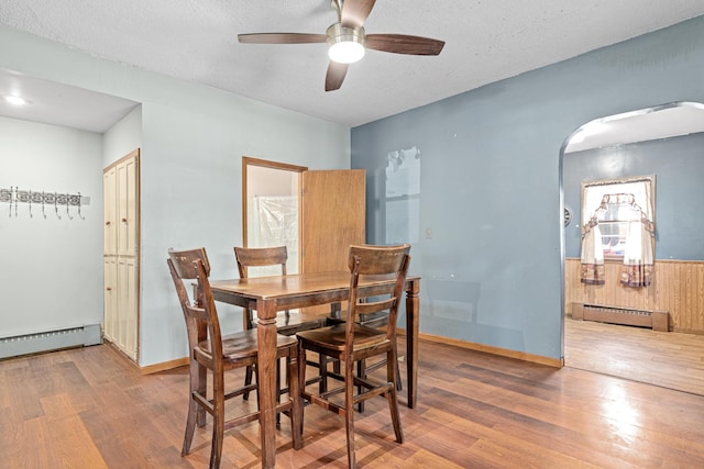 990 Virginia St, Saint Paul, MN 55117 - dining space with a baseboard heating unit, arched walkways, wood finished floors, ceiling fan, and baseboard heating