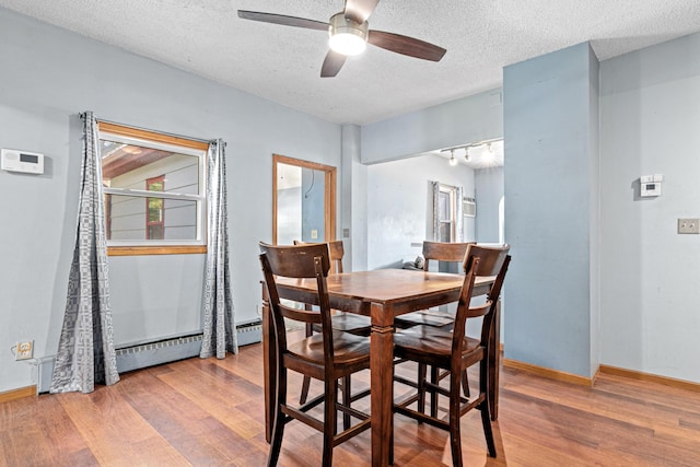 990 Virginia St, Saint Paul, MN 55117 - dining space with wood finished floors, a ceiling fan, a textured ceiling, and a baseboard heating unit