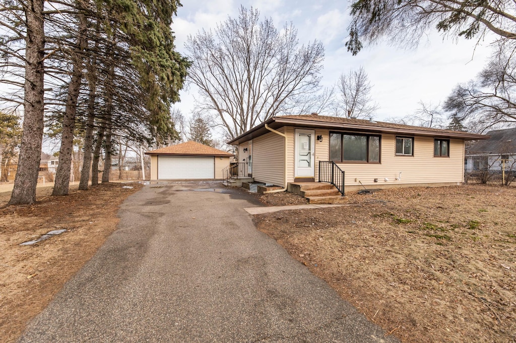 view of front of home with a garage and an outbuilding