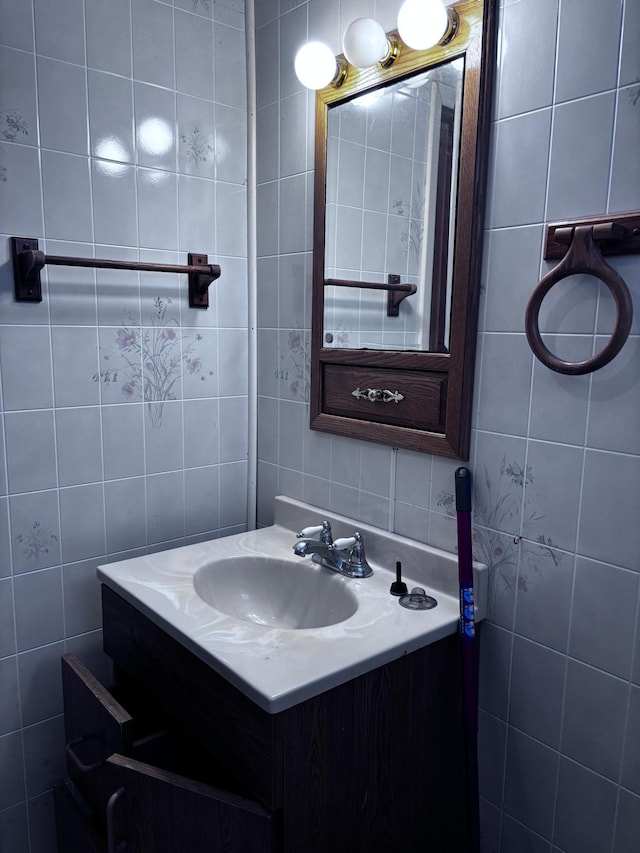 bathroom with vanity and tile walls