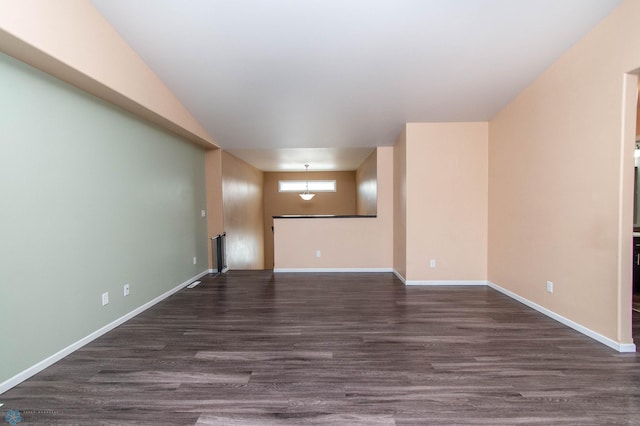 spare room featuring dark wood finished floors and baseboards