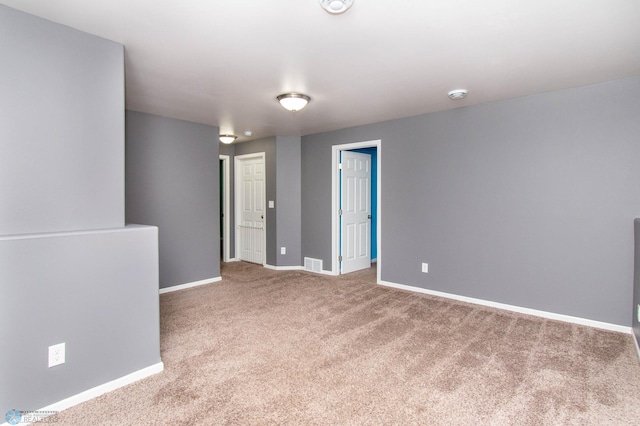 carpeted spare room featuring visible vents and baseboards