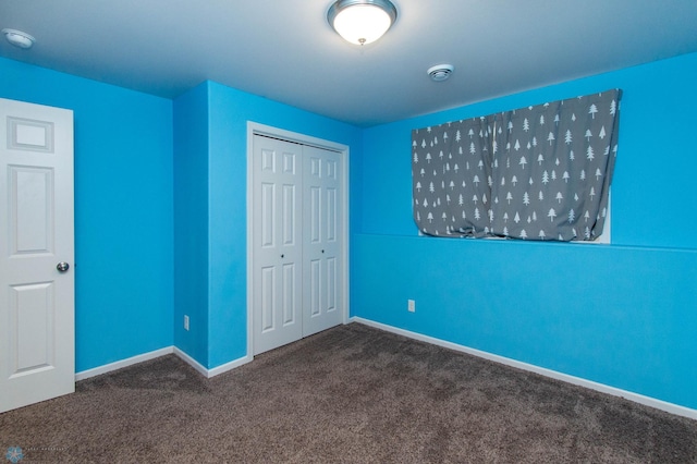 unfurnished bedroom with a closet, carpet flooring, and baseboards