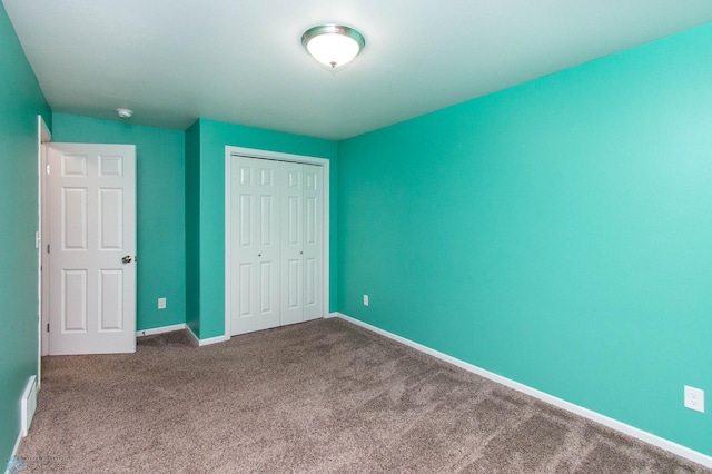 unfurnished bedroom featuring a closet, carpet flooring, visible vents, and baseboards