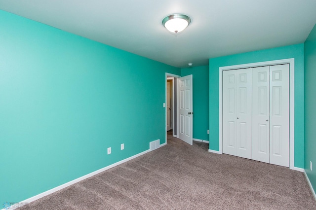 unfurnished bedroom featuring carpet floors, baseboards, visible vents, and a closet