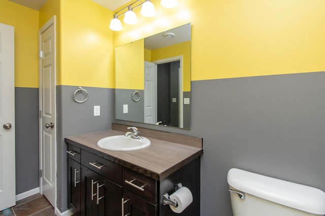 bathroom featuring toilet, tile patterned flooring, and vanity