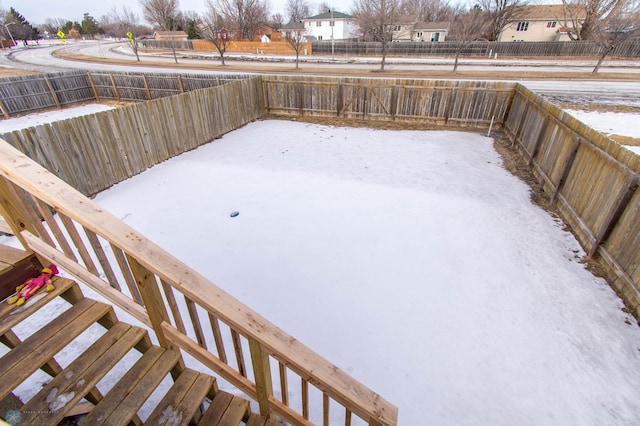 snowy yard featuring a fenced backyard