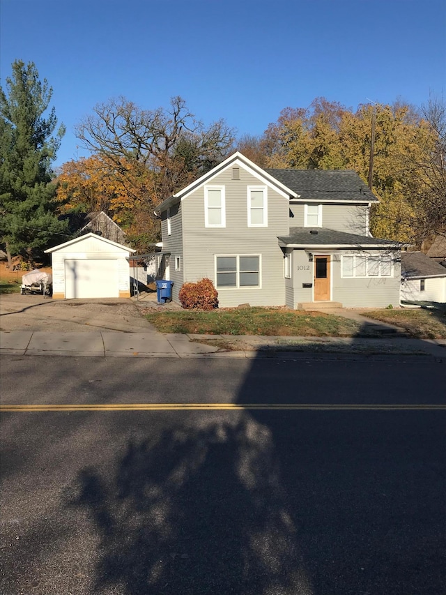 front facade with a garage and an outbuilding