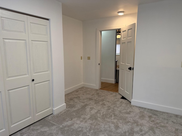 unfurnished bedroom with light carpet and a closet