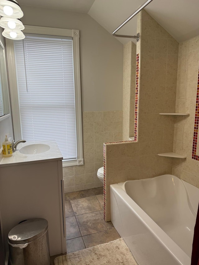 full bathroom featuring toilet, tile walls, lofted ceiling, and vanity