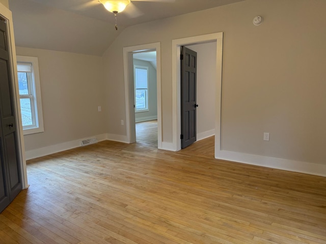 empty room with light wood-type flooring and lofted ceiling