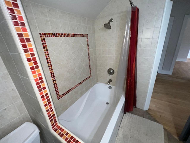 bathroom featuring shower / bath combo, vaulted ceiling, tile walls, and toilet