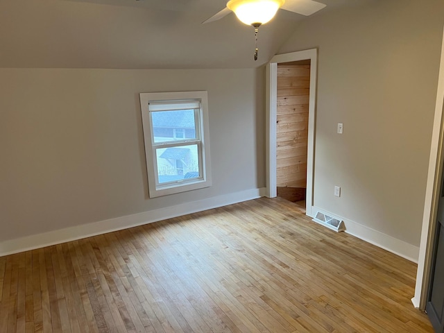 empty room featuring ceiling fan, vaulted ceiling, and light hardwood / wood-style floors