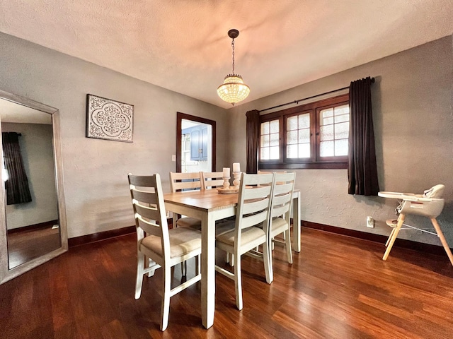 dining room featuring dark hardwood / wood-style flooring and a textured ceiling