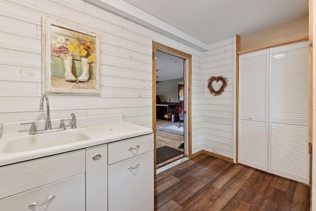 3685 Watertown Rd, Orono, MN 55359 - kitchen with wooden walls, dark wood finished floors, white cabinets, light countertops, and a sink