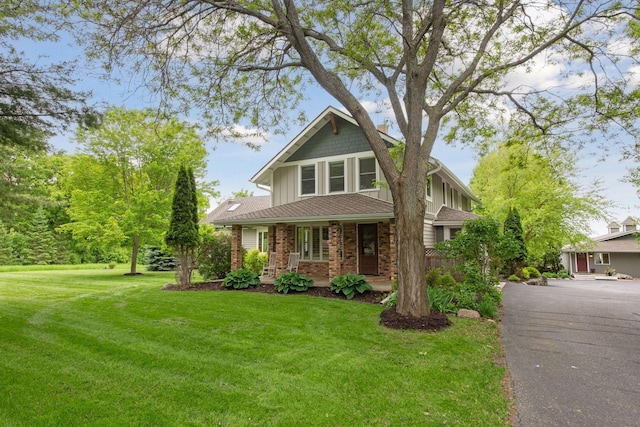 3685 Watertown Rd, Orono, MN 55359 - view of front of home featuring board and batten siding, a porch, a front yard, and brick siding