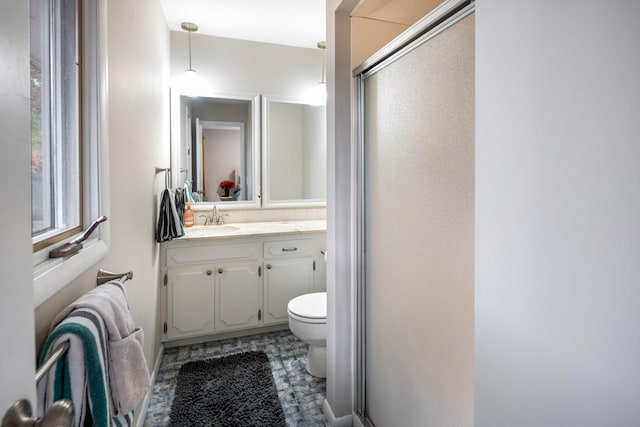 bathroom featuring vanity, decorative backsplash, a shower with door, and toilet